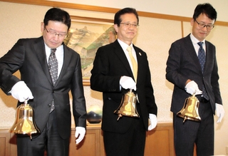 神戸ルミナリエ希望の鐘の複製版を鳴らす（左から）神戸市機械金属工業会の尾尻法行さん、同市の今西正男副市長、同会の和田貴志さん＝２９日午前、同市役所
