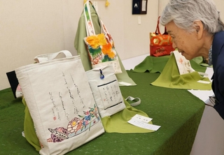 着物の帯を再利用したトートバッグに書いた作品＝神戸市灘区原田通３