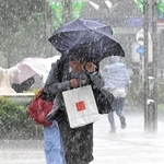 ひょう混じりの激しい雨の中を足早に歩く人たち＝１３日午後、神戸市中央区東川崎町１（撮影・斎藤雅志）