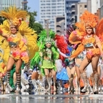 夏のような日差しでかげろうが揺らめく中、サンバを踊るパレードの参加者＝１７日午後、神戸市中央区（撮影・鈴木雅之）