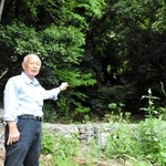 土石流が発生した斜面を背に当時の状況を説明する大重昭司さん＝神戸市灘区篠原台
