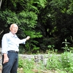 土石流が発生した斜面を背に当時の状況を説明する大重昭司さん＝８日午前、神戸市灘区篠原台
