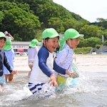 波打ち際で駆け回る園児たち＝25日午前、諸寄・塩谷浜海水浴場