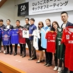 県内各スポーツチームのユニホームを掲げる関係者ら＝神戸市中央区