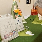 着物の帯を再利用したトートバッグに書いた作品＝神戸市灘区原田通３