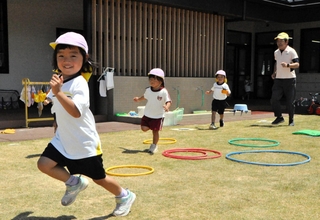 かくれんぼに夢中で芝生の園庭を駆ける園児ら＝おの幼稚園