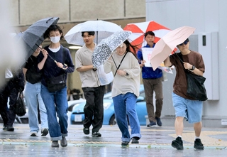 雨風が強まる中、傘を傾けながら歩く人たち＝２日午後、神戸市中央区加納町４（撮影・鈴木雅之）