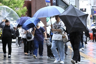 雨風が強まる中、傘を傾けながら歩く人たち＝２日午後５時45分、神戸市中央区加納町４（撮影・鈴木雅之）