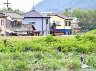 母娘の遺体発見現場（中央奥）付近の栗栖川を調べる捜査員＝４日午前１１時２２分、たつの市新宮町段之上