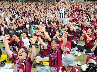 ヴィッセル神戸の優勝が決まった瞬間、両手を挙げて喜ぶサポーター＝６日午後、ノエビアスタジアム神戸