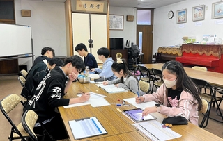 西方寺のスペースを利用して行われた寺子屋学習会の様子。大学生ら（手前）が個別指導した（志門会提供）