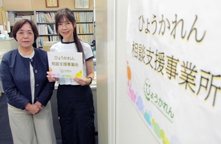 「ひょうかれん相談支援事業所」の前に立つ新銀輝子会長（左）と相談支援専門員の吉田聡子さん＝兵庫県福祉センター