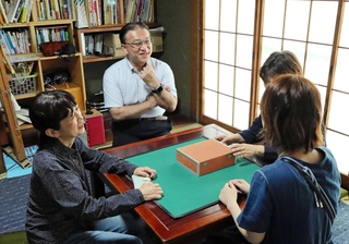 ひきこもり当事者（手前右）の悩みを聞くＮＰＯ法人「神戸オレンジの会」の藤本圭光代表（左から２人目）らスタッフ＝神戸市長田区