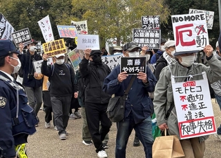 プラカードを掲げて抗議する人たち＝４月、神戸市兵庫区