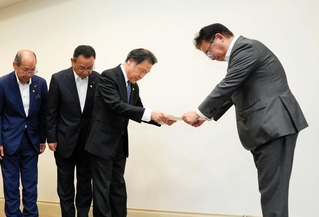 要望書を手渡す守本真一副知事（右から２人目）らと受け取る上野賢一郎厚生労働相＝２０日午後、豊岡市日高町栗栖野