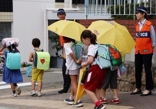 下校する児童を見守る警察官＝中央区中山手通４
