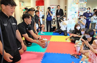 ビニール製のラグビーボールで子どもたちと触れ合うコベルコ神戸スティーラーズの選手たち＝神戸大医学部付属病院