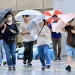 雨風が強まる中、傘を傾けながら歩く人たち＝２日午後、神戸市中央区加納町４（撮影・鈴木雅之）