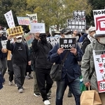 プラカードを掲げて抗議する人たち＝４月、神戸市兵庫区