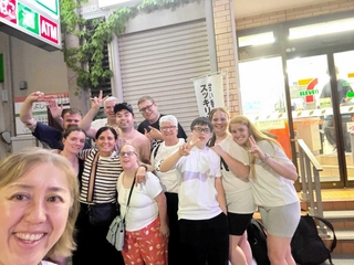 映画の一場面。日本のコンビニエンスストアの前で記念撮影　（Ｃ）２０２６　Ｃａｌ　Ｗｅａｒ　Ｆｉｌｍｓ　ａｎｄ　Ｗｏｒｋ　Ｌｔｄ　Ｓｔｕｄｉｏ