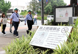 過料２万円に引き上げられた路上喫煙禁止区域を巡回する姫路市の指導監視員ら＝１日午前、姫路市本町