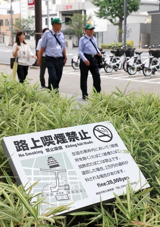 過料２万円に引き上げられた路上喫煙禁止区域を巡回する姫路市の指導監視員ら＝１日午前、姫路市白銀町