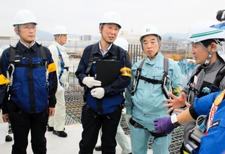 工事現場で安全対策について説明を受ける兵庫労働局の金成真一局長（左端）ら＝神戸市兵庫区中之島１