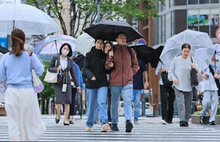雨の中を歩く人たち。気温が上がらず厚着の人も＝６月２日、神戸市中央区