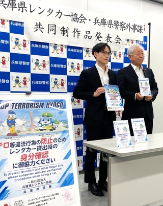 ポスターなどの啓発グッズを発表する松岡裕人外事課長（左）と桐月忍一郎会長＝兵庫県警本部