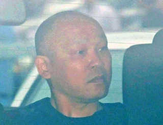 捜査車両に乗せられて長田署を出る菱川龍己容疑者＝６月２４日、神戸市長田区北町３