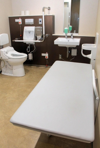 多目的トイレに設置された折りたたみ式の介助用ベッド＝神戸市役所