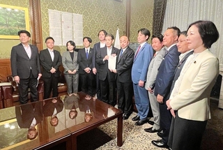 公職選挙法などの改正案を提出した与野党の衆院議員ら＝６月２４日、国会内