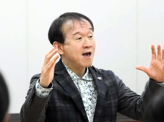 指揮をしながら学生らと歌う臼井真さん＝２０２４年１２月、神戸市北区鈴蘭台北町７、神戸親和大学