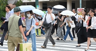 今夏初の熱中症警戒アラートが県内に発令され、携帯扇風機や日傘を手に歩く人たち＝１３日午前、神戸市中央区元町通１（撮影・大田将之）