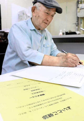 面談前に生活習慣などを尋ねる健診票に記入する＝コープリビング甲南