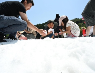 夏空の下、人工雪で遊ぶ子どもら＝１８日午前、神戸市灘区六甲山町北六甲、六甲山アスレチックパークグリーニア（撮影・斎藤雅志）