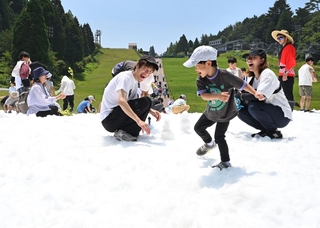 夏空の下、人工雪で遊ぶ子どもら＝１８日午前、神戸市灘区六甲山町北六甲、六甲山アスレチックパークグリーニア（撮影・斎藤雅志）