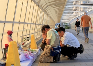 歩道橋事故から25年。献花し、静かに手を合わせる人たち＝21日午後６時１分、明石市大蔵海岸通１（撮影・丸山桃奈）