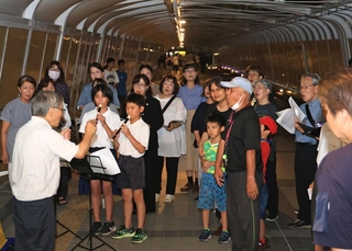 事故のあった歩道橋でで鎮魂歌を捧げる市民ら＝21日夜、明石市大蔵海岸通１（撮影・丸山桃奈）