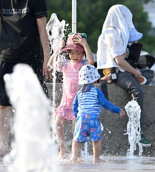 暑さを和らげるため噴水の周りで遊ぶ子どもら＝２２日午後、神戸市中央区波止場町（撮影・風斗雅博）