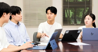 ＺＢＯＳＡＩ代表の谷口隆英さん（右から２人目）。活動を共にするメンバーとの議論にも熱がこもる＝西宮市内