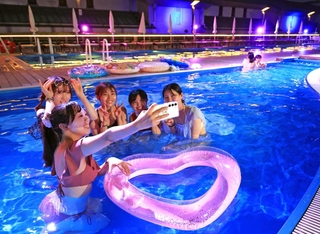夜のプールを楽しむ人たち＝神戸市中央区港島中町６