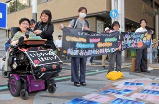 障害の有無で人の価値を決めつけない社会を求め、街頭で声を上げる人たち＝２６日夕、神戸市中央区三宮町１、三宮センター街東口