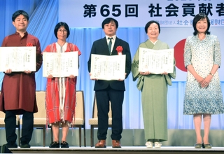 社会貢献者表彰を受賞したＮＰＯ法人「ＣＯＤＥ海外災害援助市民センター」の吉椿雅道事務局長（中央）＝東京都千代田区