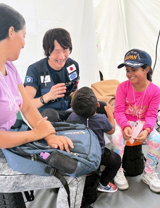 診療中の子どもの緊張を和らげるため声をかける成俊浩さん（左から２人目）＝ベネズエラのラグアイラ州、国際協力機構（ＪＩＣＡ）提供