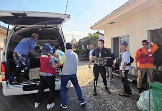 断水が発生している住宅で水を配る支援者ら＝３０日、熊本県八代市（増島智子さん提供）