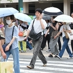 今夏初の熱中症警戒アラートが県内に発令され、携帯扇風機や日傘を手に歩く人たち＝１３日午前、神戸市中央区元町通１（撮影・大田将之）