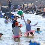 日差しが照りつける中、水遊びを楽しむ親子連れら＝20日午後、神戸市垂水区海岸通（撮影・丸山桃奈）
