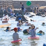 日差しが照りつける中、水遊びを楽しむ人たち＝20日午後、神戸市垂水区海岸通（撮影・丸山桃奈）