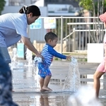 暑さを和らげるため噴水の周りで遊ぶ親子ら＝２２日午後、神戸市中央区波止場町（撮影・風斗雅博）
